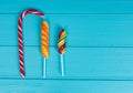 Three tasty lollipops on wooden turquoise table Royalty Free Stock Photo