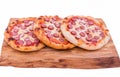 Three tasty pepperoni pizzas. Top view of hot pepperoni pizzas on a wooden tray, board, dish. The object is isolated on a white Royalty Free Stock Photo