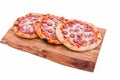 Three tasty pepperoni pizzas. Top view of hot pepperoni pizzas on a wooden tray, board, dish. The object is isolated on a white Royalty Free Stock Photo