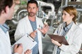 three technicians in discussion holding clipboards Royalty Free Stock Photo