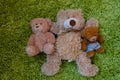 Three teddy bears laying on green furry carpet Royalty Free Stock Photo