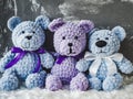 Three teddy bears, sitting on a white plaid