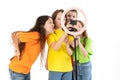 Three teen girls and a boy smiling and shoots a video. Selfies. The phone is mounted on a tripod and the ring lamp shines.Negative