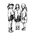 Three teenage girls in raincoats stand next to each other