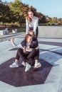 Three teenage girls of schoolgirls 12-14 years old, in summer in city, ride skateboard, happy smiling, having fun Royalty Free Stock Photo