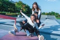 Three teenage girls teenagers ride skateboard, happy have fun playing and laughing, summer sports ground, in warm Royalty Free Stock Photo