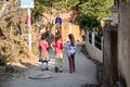Three teenage Indian girls walk down an alley in the city, back view