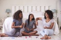 Three Teenage Sisters Giving Each Other Makeover In Bedroom