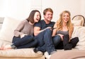 Three teenagers enjoy a funny television program