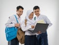 Three teenagers in junior high school uniforms smiling using a laptop computer together while carrying a backpack and a Royalty Free Stock Photo