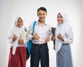 Three teenagers in school uniforms smiled with excited hands gesture when carrying a backpack and a book