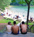 Red Top Mountain, Georgia-circa July, 2019: Three teenagers sit on a stoop in the shade eating popsicles and watching people play