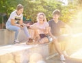 Three teenagers with smartphones are talking about play on walk Royalty Free Stock Photo