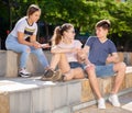 Three teenagers with smartphones are talking about play on walk Royalty Free Stock Photo