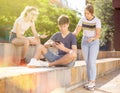 Three teenagers with smartphones are talking about play on walk Royalty Free Stock Photo