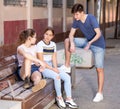 Three teenagers with smartphones are talking about play on walk Royalty Free Stock Photo