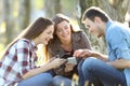 Three teens sharing on line content on phones