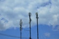 Three telecommunication towers cells for mobile communications against cloudy sky. Three base radio station Royalty Free Stock Photo