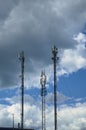 Three telecommunication towers cells for mobile communications against cloudy sky. Three base radio station Royalty Free Stock Photo