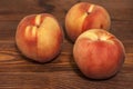 Three tender ripe peaches on a wooden table. Close up Royalty Free Stock Photo
