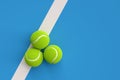 Three tennis balls on the court line or side line on blue background with copy space