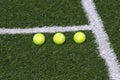 Three tennis balls on green court Royalty Free Stock Photo