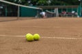 Three tennis balls lie together on a red clay court. Blur background Royalty Free Stock Photo