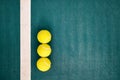 Three tennis balls near the line of a concrete court Royalty Free Stock Photo