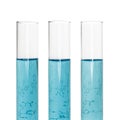Three test tubes with blue liquids and sheet of paper with formulas isolated on white background. Royalty Free Stock Photo