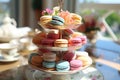 A three tiered cake stand with macarons and tea cups, AI Royalty Free Stock Photo