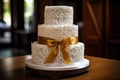 three-tiered wedding cake, with intricate lace and ribbon detailing