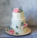 Three tiered wedding Cream cheese cake with roses and eucalyptus Royalty Free Stock Photo