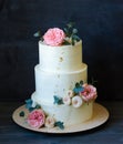 Three tiered wedding Cream cheese cake with roses and eucalyptus Royalty Free Stock Photo