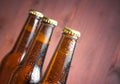 Three tilted bottles of fresh beer with drops Royalty Free Stock Photo