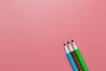 Three tilted colorful pen opened pen cap set on pink background