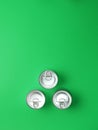 Three tins of food isolated on green background