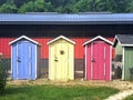 Three Tiny Houses, Blue, Yellow and Red, with green lawn in front, Tiny Homes, Outhouses, Toilets, Restroom, Cute Wooden Building