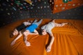 Three tired climbers on the mat near rock wall indoors Royalty Free Stock Photo