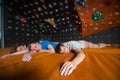 Three tired climbers on the mat near rock wall indoors Royalty Free Stock Photo