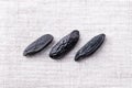 Three tonka beans, close-up, from above, on linen Royalty Free Stock Photo