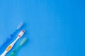 Three tooth brushes on blue background - top view