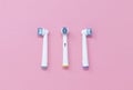 Three toothbrush heads isolated on a pink background, with space for copy