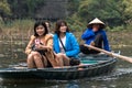 Three tourist and rower on a tour along the river in Tam Coc