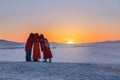 Three tourist taking selfie in sunset at frozen lake Baikal in Siberia, Russia. Travelling in winter