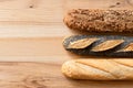 Three traditional baguettes on light wood. Plain, whole wheat and poppy seed. Top view. Space for text