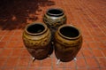 Three of traditional Thai water jar and Thai old handcraft art mold place on orange brick tile floor background in sunny day.The