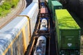 Three trains riding on the railroad tracks surrounded by lush green trees and bare winter trees in Atlanta