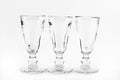 Three transparent elegant crystal glasses for cocktails on a white background