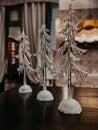 Three transparent figures of Christmas trees stand on a dark shelf