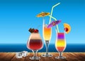 Three transparent glass with a multi-colored refreshing cocktail, decorated with a cocktail umbrella and a slice of lemon, Highly